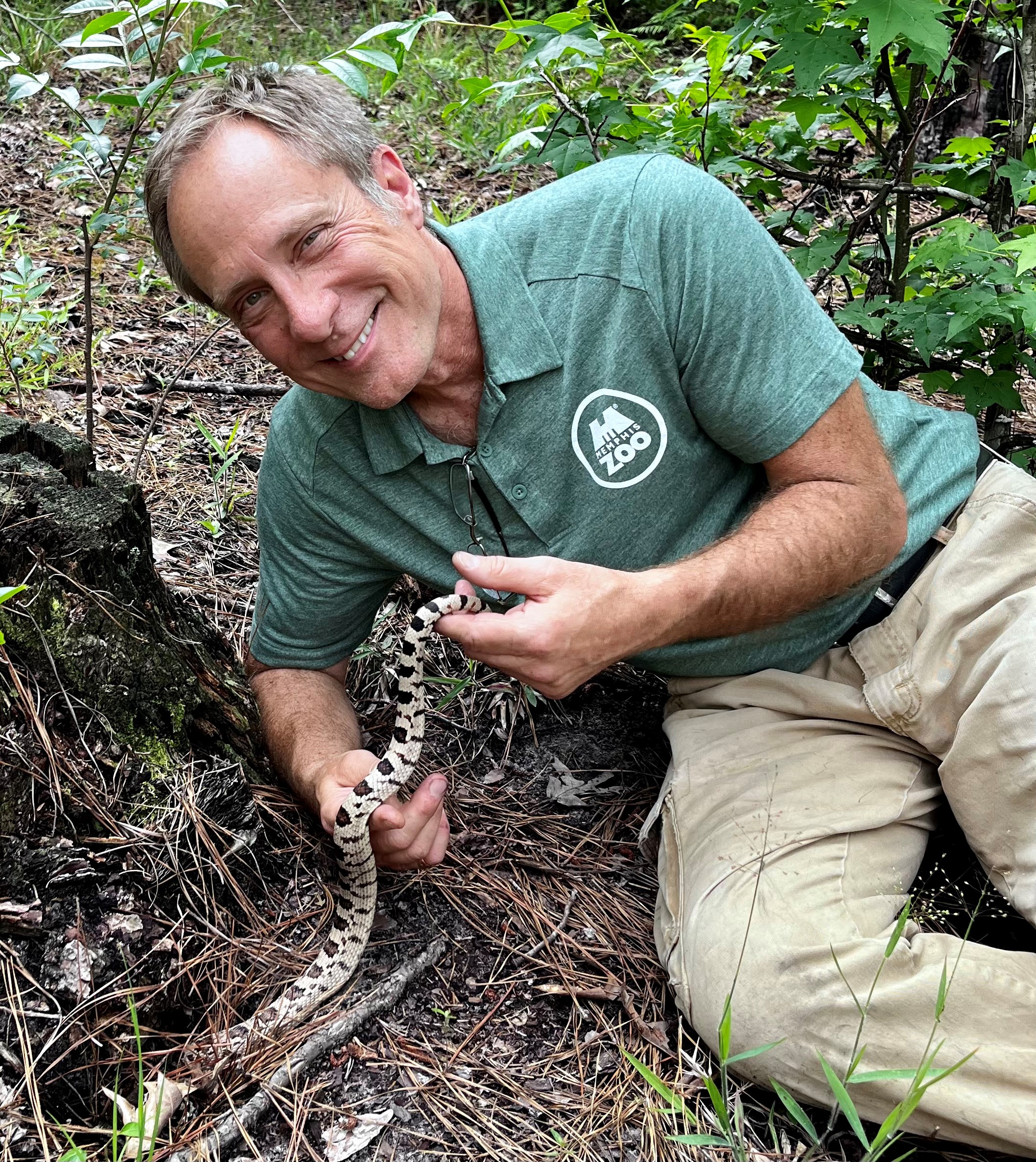 Dr. Reichling posing with snake in longleaf pine ecosystem